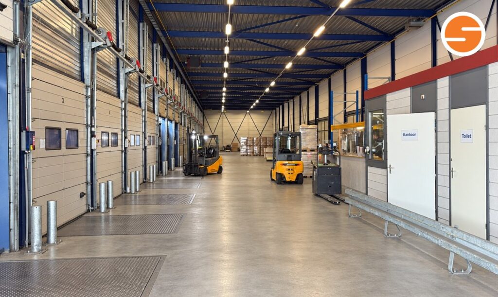 Laaddeuren, heftrucks en een palletwagen in het distributiecentrum aan de Loubergweg in Eerbeek